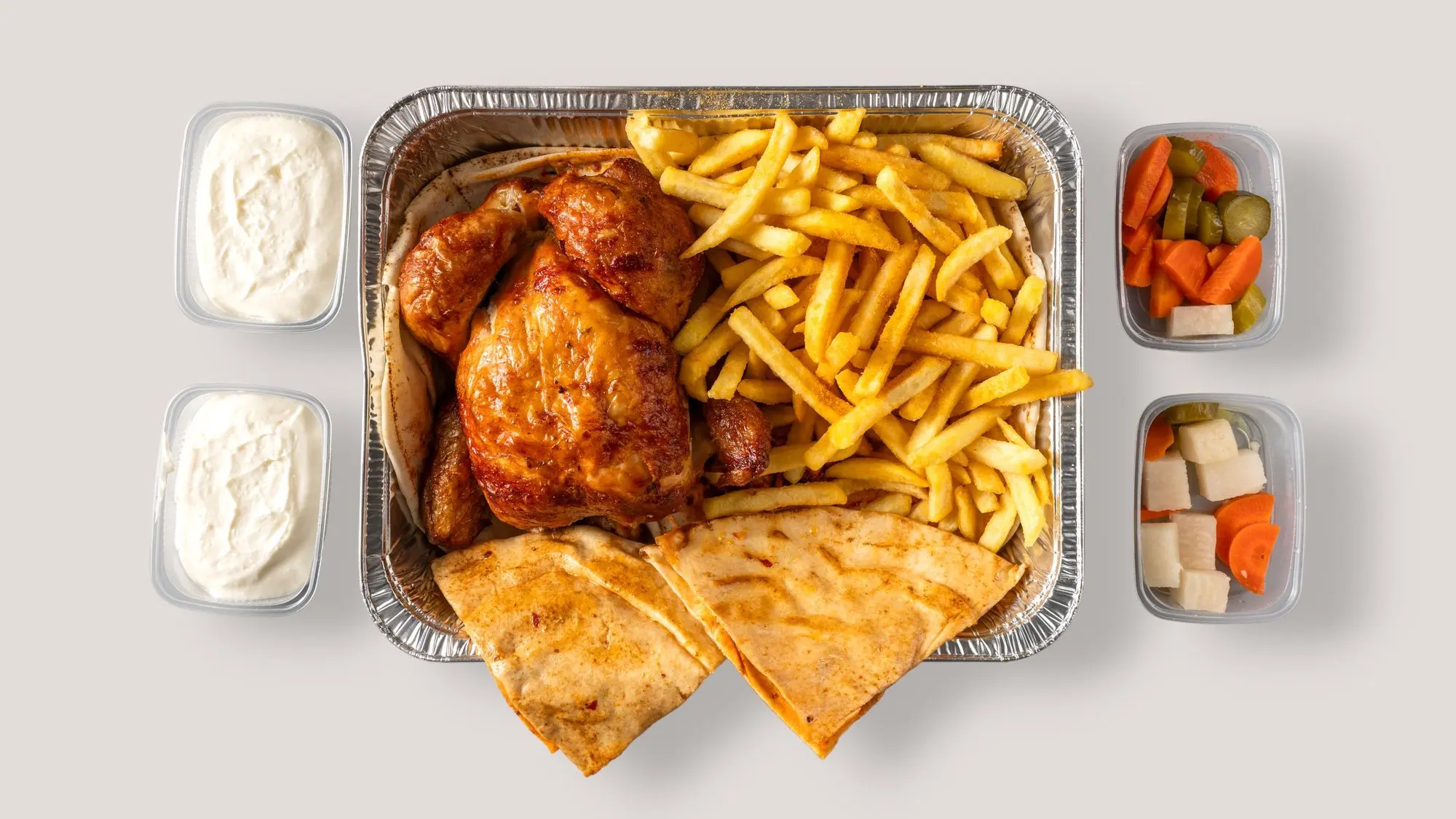 Boîte pour emporter : poulet, frites, pita, sauces et légumes marinés